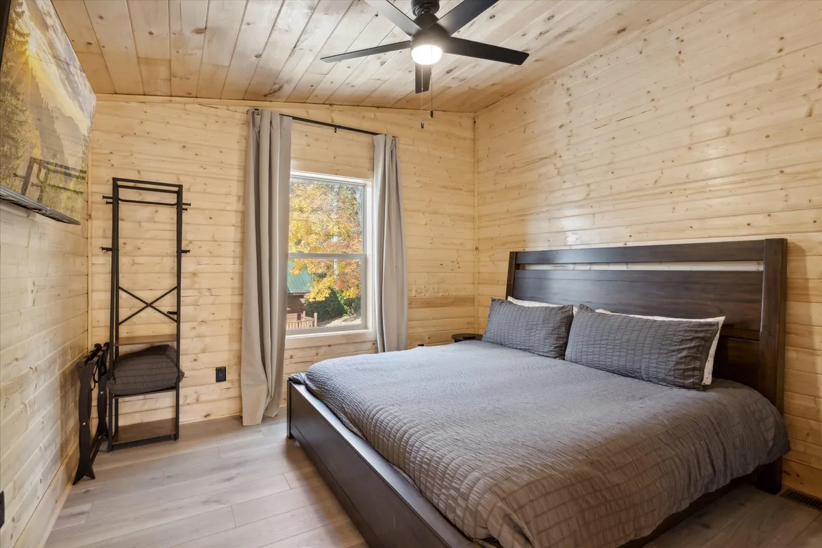 A peaceful bedroom is shown, with a comfortable bed positioned next to a window. Artwork adds a personal touch, and the overall decor exudes a sense of calm and serenity, inviting relaxation and restful sleep.